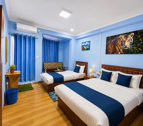 two beds in a room with blue walls at Chautara Restro & Inn in Kathmandu