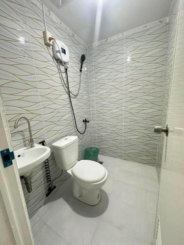 a bathroom with a toilet and a sink at Green Meadows Residence Naga in Milaor