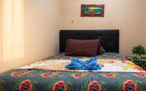 a bed with a blue bow on top of it at GWK View Boutique Hotel and Serviced Residence in Jimbaran
