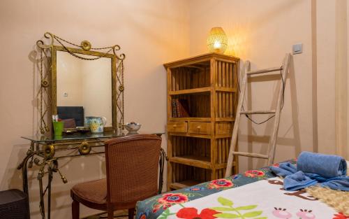 a bedroom with a desk and a mirror and a table at GWK View Boutique Hotel and Serviced Residence in Jimbaran