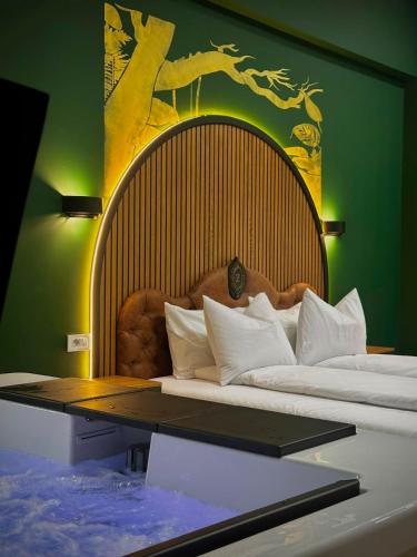 a bedroom with two beds with a large headboard at Hotel Zouk Suite Spa in Alba Iulia