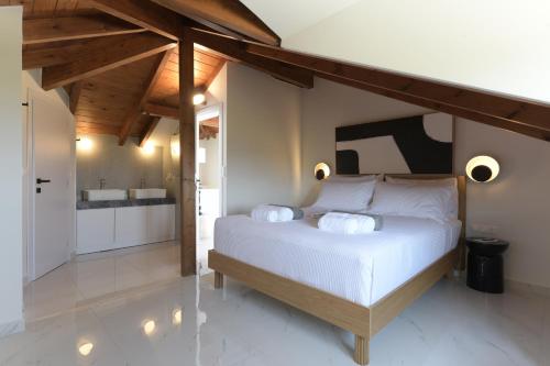 a bedroom with a white bed and a bathroom at Azoria Villa in Haraki