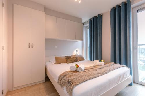a bedroom with a large bed with blue curtains at Whaaw Oostende in Ostend