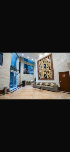a living room with a couch and a painting on the wall at فندق روشن كدي in Al Masfalah