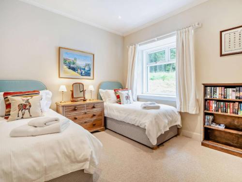 a bedroom with two twin beds and a window at Upper Hillside Cottage in Blairgowrie
