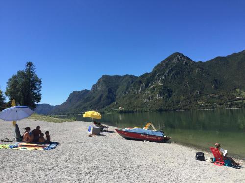 a group of people sitting on a beach with a boat at Casa Paola in Vesta
