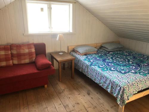 a bedroom with a bed and a couch and a window at Waldhaus mit Seeblick in Nyhammar