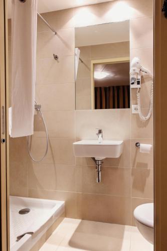 ein Badezimmer mit Waschbecken, Toilette und Dusche in der Unterkunft Hotel Astrid Caen centre in Caen