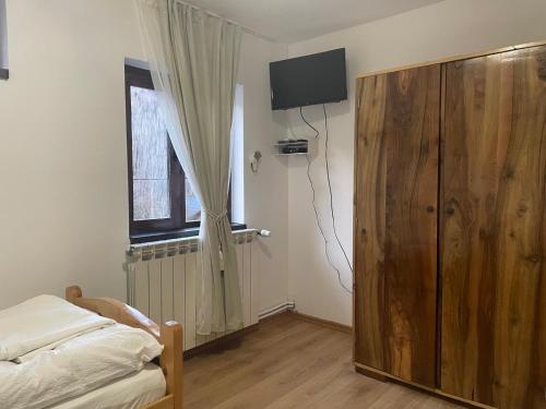 a bedroom with a bed and a window and a television at Cabana Elena in Rausor