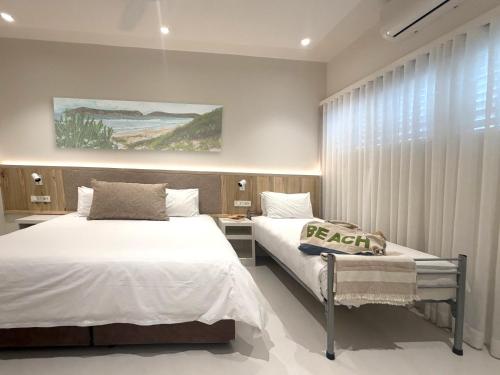 a bedroom with two beds and a window at Plett Beachfront Guest House in Plettenberg Bay