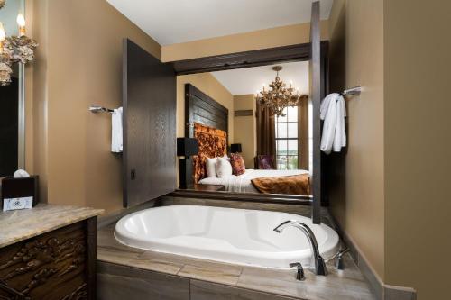 a bath tub in a bathroom with a bedroom at Bohemian Hotel Savannah Riverfront, Autograph Collection in Savannah