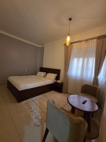 a hotel room with a bed and a table at Paramount Boutique Hotel in Entebbe