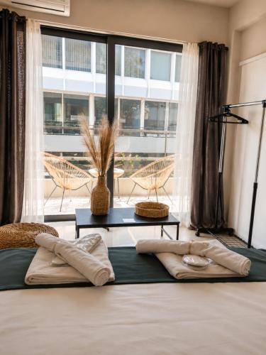a bedroom with a bed and a large window at Nino Suite, Central Pyrgos in Pyrgos