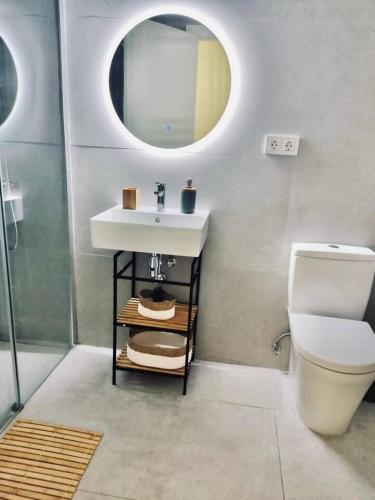a bathroom with a sink and a toilet and a mirror at Paraísos de Agaete in Puerto de las Nieves