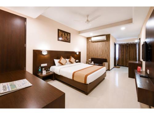 a hotel room with a bed and a desk at Hotel Park Premium With Restaurant & Banquet Ujjain - By D S Stay Group in Ujjain