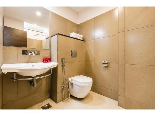 a bathroom with a toilet and a sink and a shower at Hotel Park Premium With Restaurant & Banquet Ujjain - By D S Stay Group in Ujjain