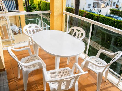 a white table and chairs on a balcony at Dénia Palm Garden Apartment Pool & Parking in Denia