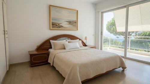 a bedroom with a bed and a large window at Kineta Prime Suites No1 in Kineta