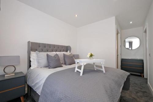 a bedroom with a white bed with a white table at Kirkton House in Kirkton of Skene