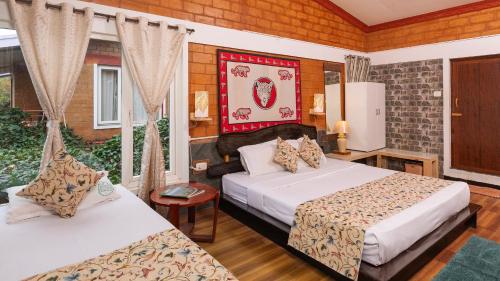 a hotel room with two beds and a window at De Rock Jungle Living Resort in Coonoor