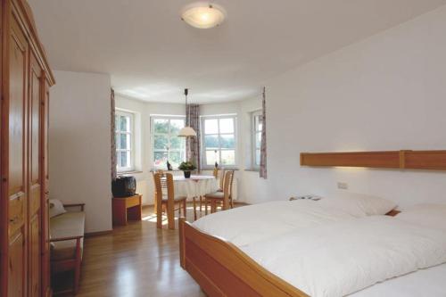 a bedroom with a bed and a dining room with a table at Landgasthof Cafe Gut Ahe in Kirchhundem
