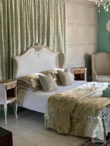 a bedroom with a bed with a white headboard at Les Menendos in Saint-Jean-de-Barrou