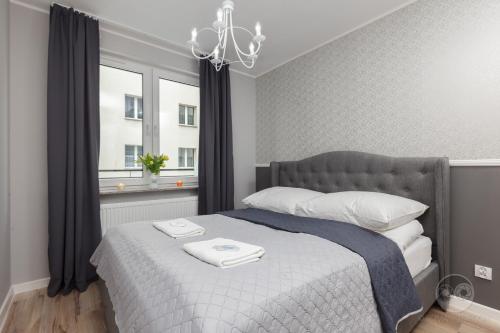 1 dormitorio con 1 cama grande y ventana en Apartment Royal I, en Białystok