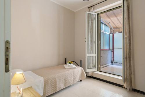 a bedroom with a bed and a large window at Appartamento Rina Centro Sicilia in Pietraperzia