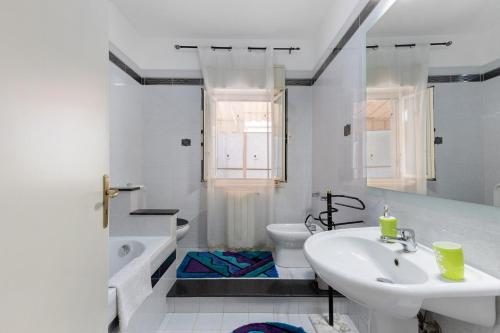a white bathroom with a sink and a toilet at Appartamento Rina Centro Sicilia in Pietraperzia