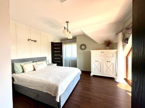 a bedroom with a bed and a white cabinet at Biały Dom in Gdańsk