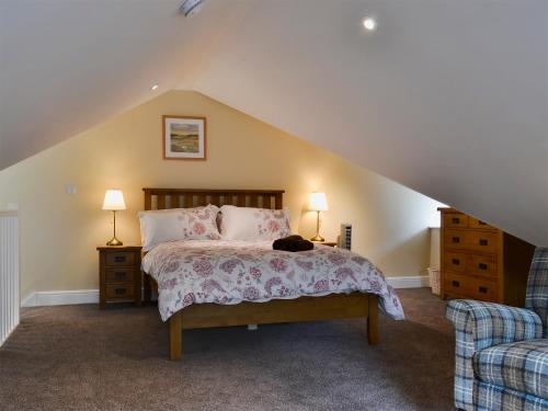 a bedroom with a bed with a cat laying on it at The Hayloft in Hunstanton