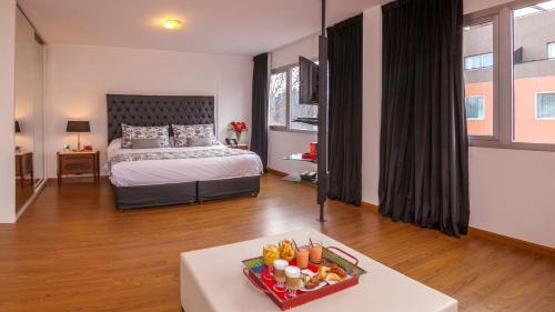 a bedroom with a bed and a table with a tray of food at Be Hollywood! in Buenos Aires