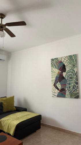 a living room with a couch and a painting on the wall at Casa da Margarida in Castro Marim