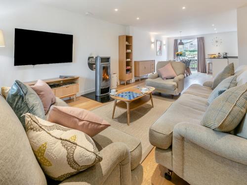 a living room with couches and a flat screen tv at Lodge 52 Una in Carbis Bay