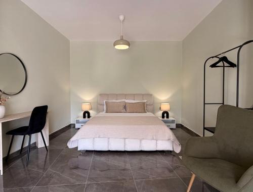 a white bedroom with a bed and a chair at Bistro 49 Luxury suites in Katerini