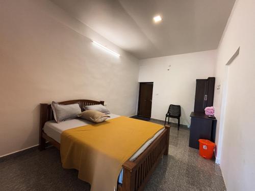 a bedroom with a bed with a yellow blanket on it at EcoHills in Anachal