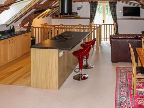 a kitchen with a counter and a red stool at The Granary in Aldbrough