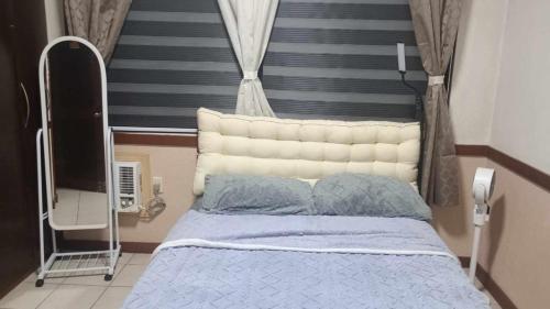 a bedroom with a bed with a white head board at Trip Nest Rentals in Dauis