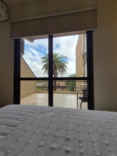 ein Schlafzimmer mit einem Bett und einem großen Glasfenster in der Unterkunft River Hotel in Uruguaiana