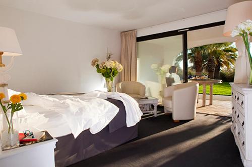 a bedroom with a bed and a table and chairs at Mangio Fango Hotel et Spa in Saintes-Maries-de-la-Mer