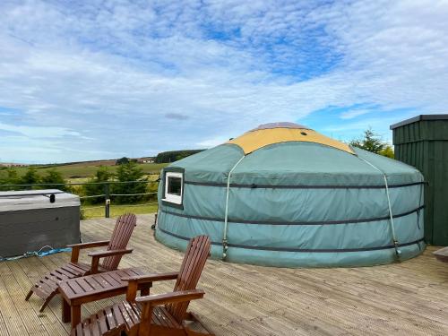a dome tent sitting on a deck with two chairs at Orange Yurt - Uk48018 in Gamrie