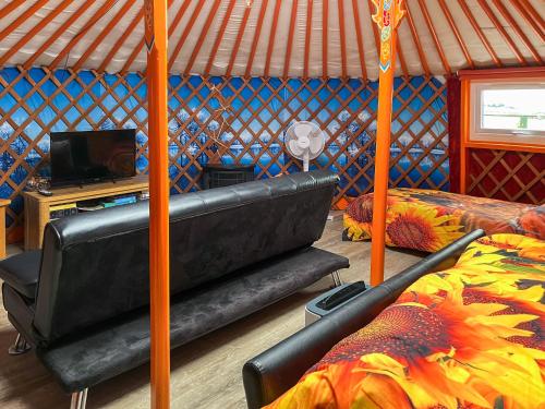 a room with a bed and a couch in a yurt at Orange Yurt - Uk48018 in Gamrie