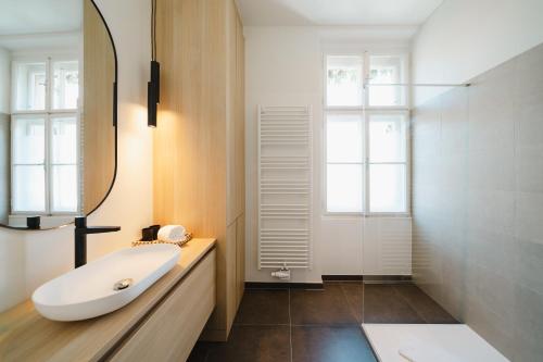 a bathroom with a white sink and a mirror at GH Luxury Apartments Graz, Gösser Haus in Graz