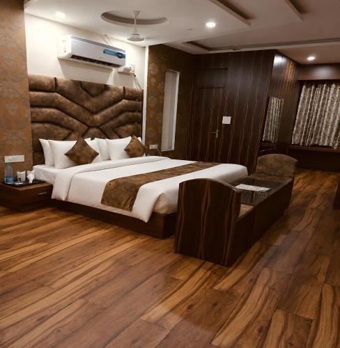a bedroom with a large bed and wooden floors at Hotel KMG Air Cooled,Zirakhpur Chandigarh ,Couple first choice ,verified hotel in Zirakpur