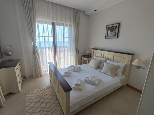 a bedroom with a large bed with towels on it at Thracian Cliffs Owners Apartments in Kavarna
