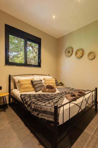 a large bed in a room with a window at Kálos Housing - Adults Only in Kolymbia