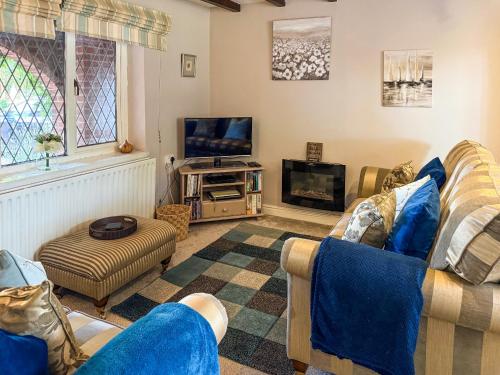 a living room with a couch and a tv at The Old Barn-E1425 in Addlethorpe