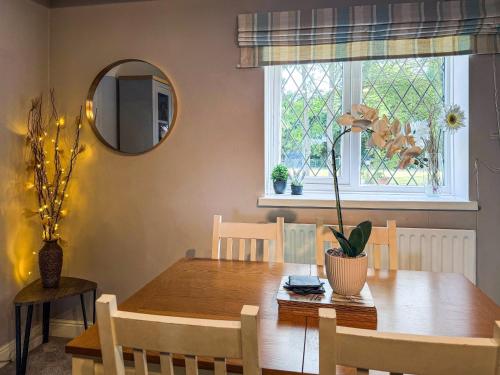 a dining room with a wooden table and a mirror at The Old Barn-E1425 in Addlethorpe