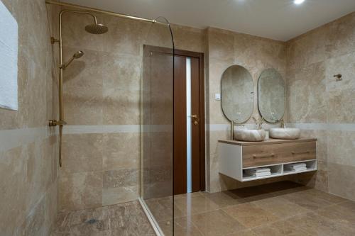 a bathroom with a shower and two mirrors at Casa Real in Sveti Vlas