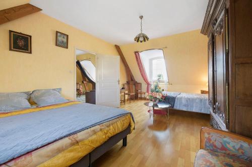 a bedroom with a bed and a room with a table at La tourelle de la croix in Picauville